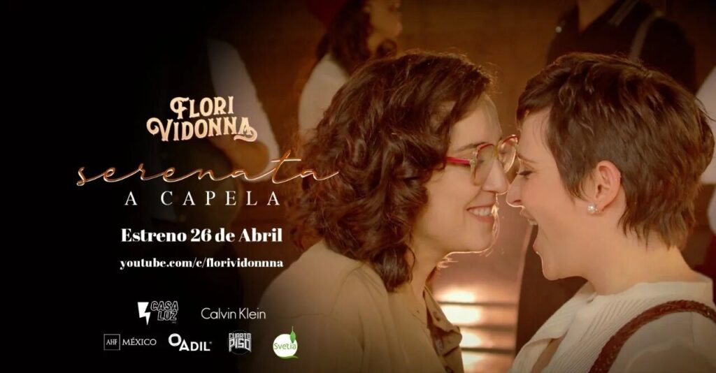 Cartel promocional de “Serenata a capela” de Flori Vidonna, con dos mujeres sonriendo frente a frente, anuncio de estreno el 26 de abril en YouTube.